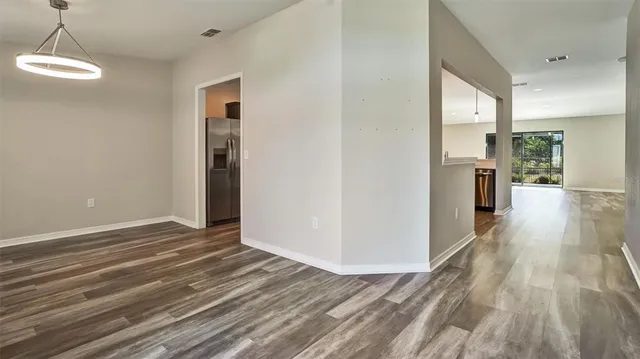 a view of a room with wooden floor and a kitchen space