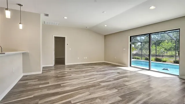 a view of an empty room with glass door and a window