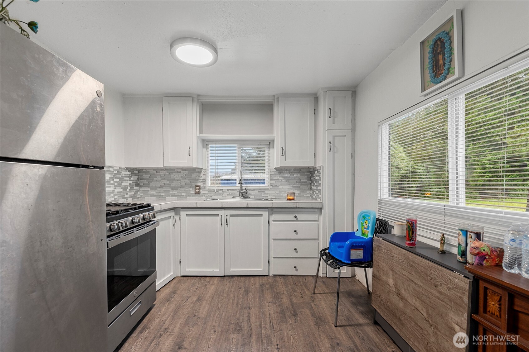 20420 Lafayette Road, Unit 11 Burlington, WA 98233 - Photo 2 of 14 a kitchen with granite countertop a stove a sink dishwasher a refrigerator and white cabinets with wooden floor