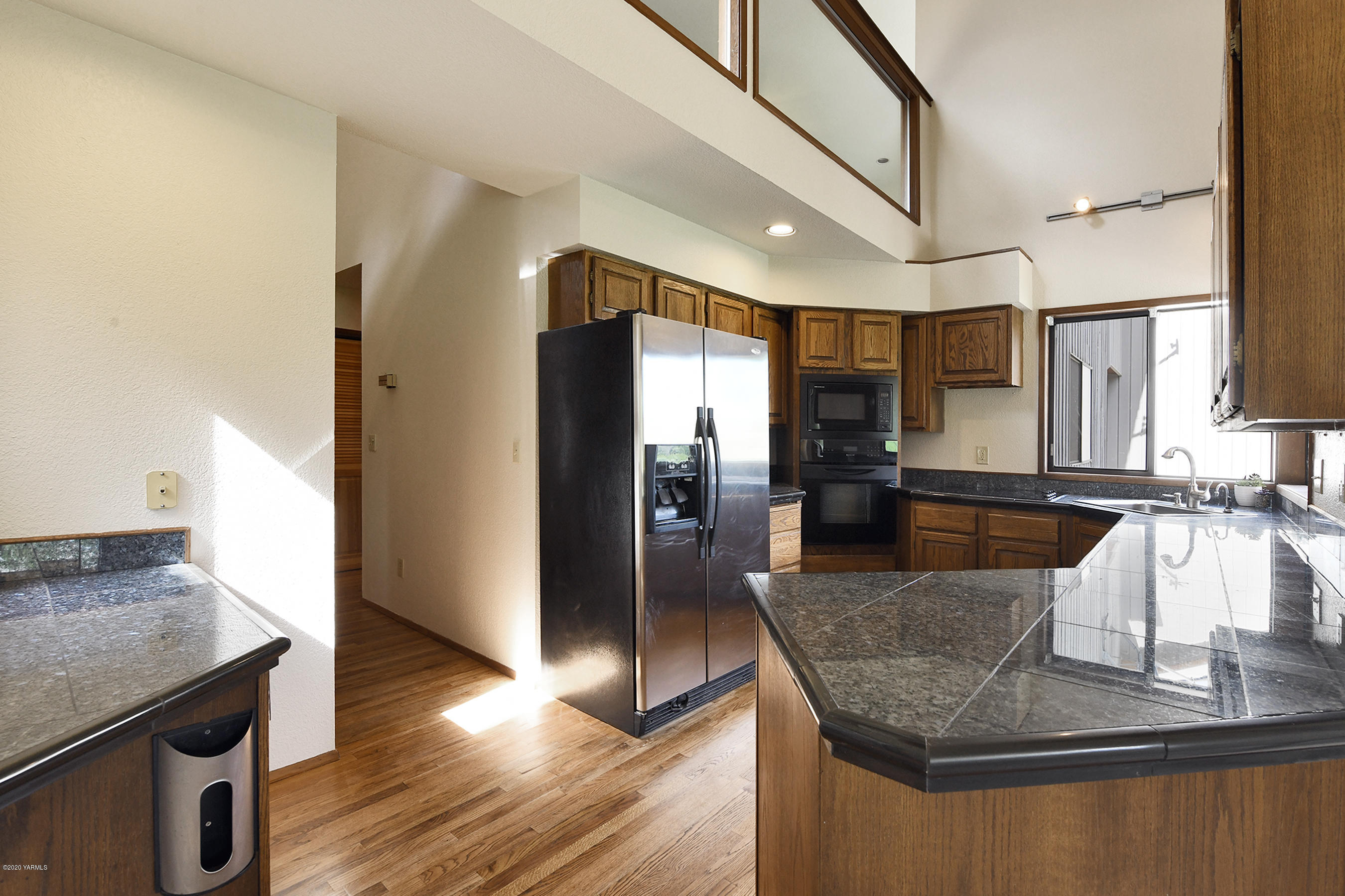 13010 Rutherford Road Yakima, WA 98903 - Photo 11 of 39 a kitchen with stainless steel appliances granite countertop a sink a microwave and wooden floor