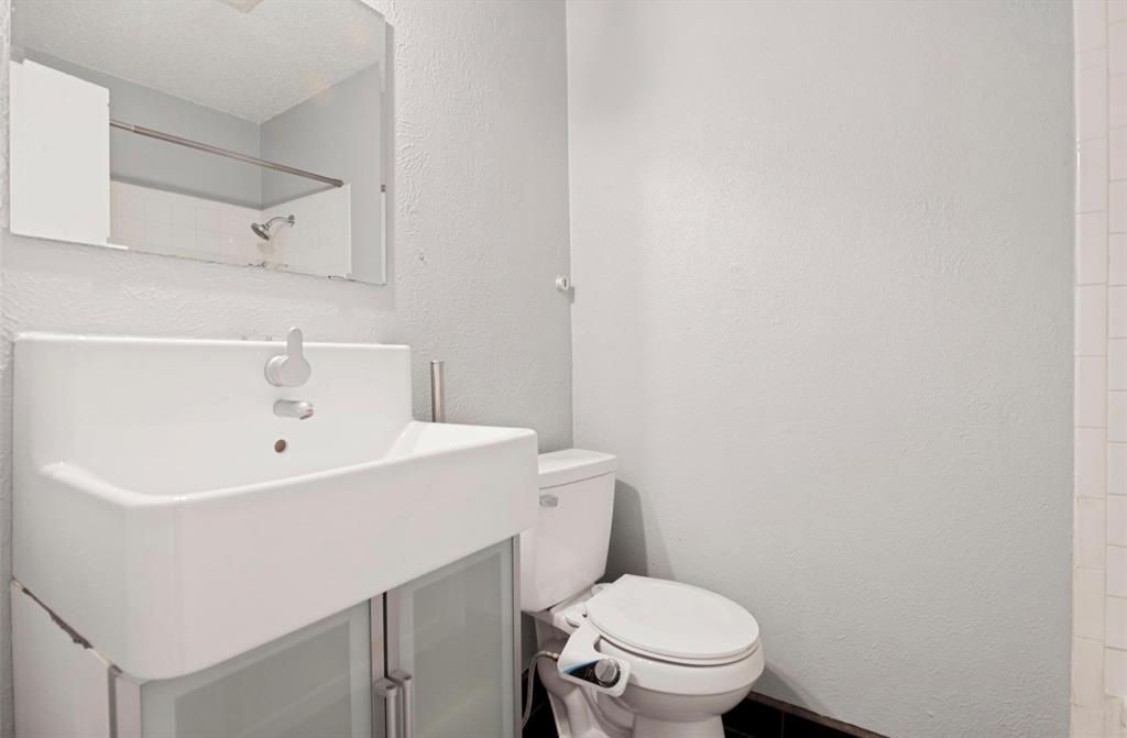 5808 Harvest Hill Road Dallas, TX 75230 - Photo 14 of 18 Modern vanity with a rectangular basin sink and single-handle faucet, featuring a wall-mounted mirror
