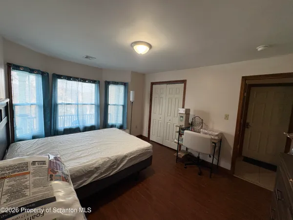 a bedroom with a bed and wooden floor