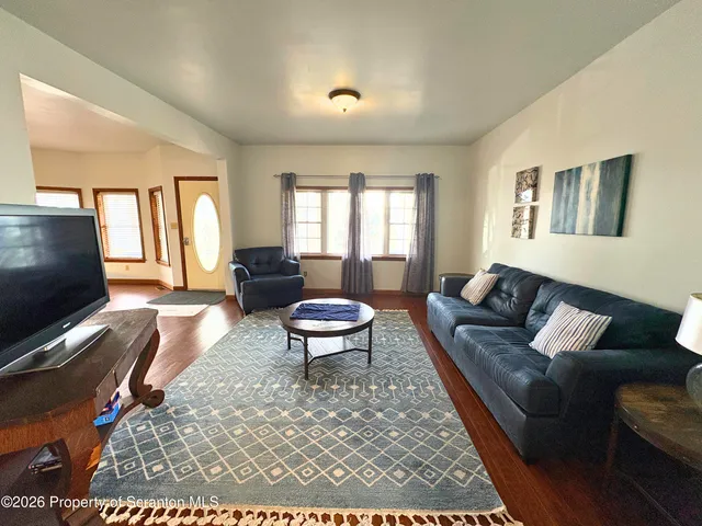 a living room with furniture a flat screen tv and a window