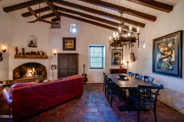 a living room with furniture a fireplace and a chandelier