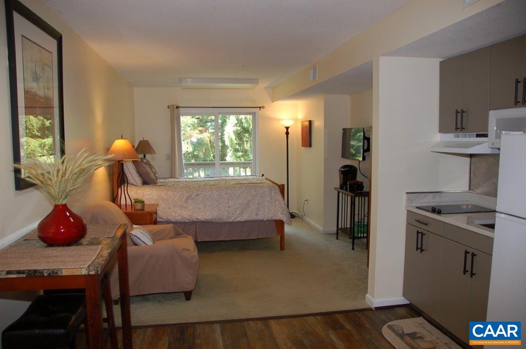 a bedroom with a bed and large windows