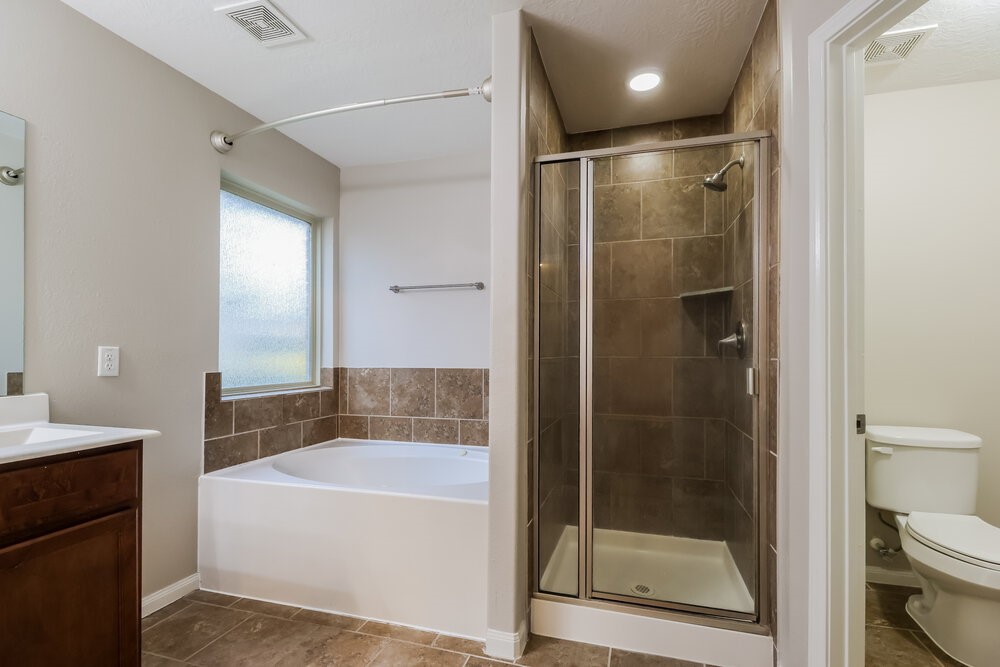226 Fantasy Lane Montgomery, TX 77356 - Photo 11 of 17 a bathroom with a shower a bathtub and a glass door shower