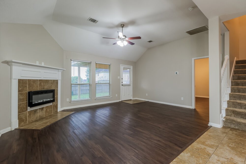 226 Fantasy Lane Montgomery, TX 77356 - Photo 4 of 17 an empty room with wooden floor fireplace and windows