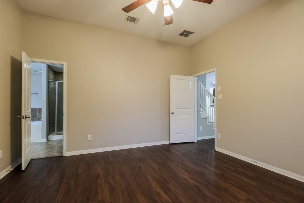 226 Fantasy Lane Montgomery, TX 77356 - Photo 10 of 17 an empty room with wooden floor and a ceiling fan