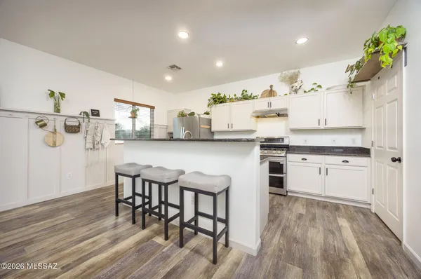 a kitchen with granite countertop white cabinets and stainless steel appliances