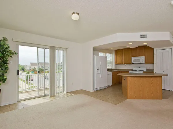 a large white kitchen with a large window and kitchen view