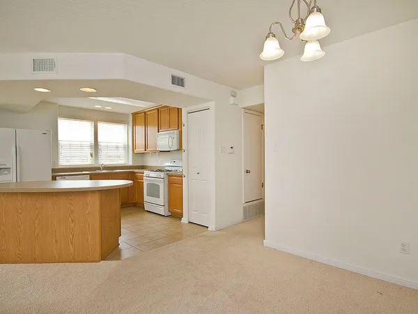 a kitchen with stainless steel appliances a stove a chandelier and a refrigerator