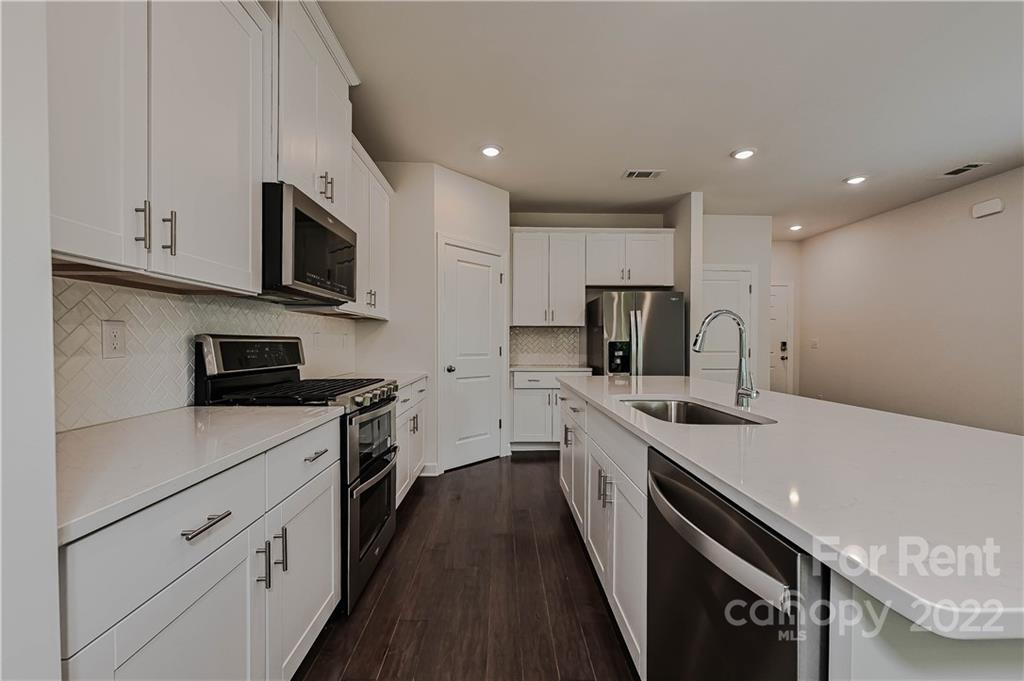 3534 Auburn Curb Road Charlotte, NC 28217 - Photo 5 of 11 a kitchen with white cabinets stainless steel appliances and sink