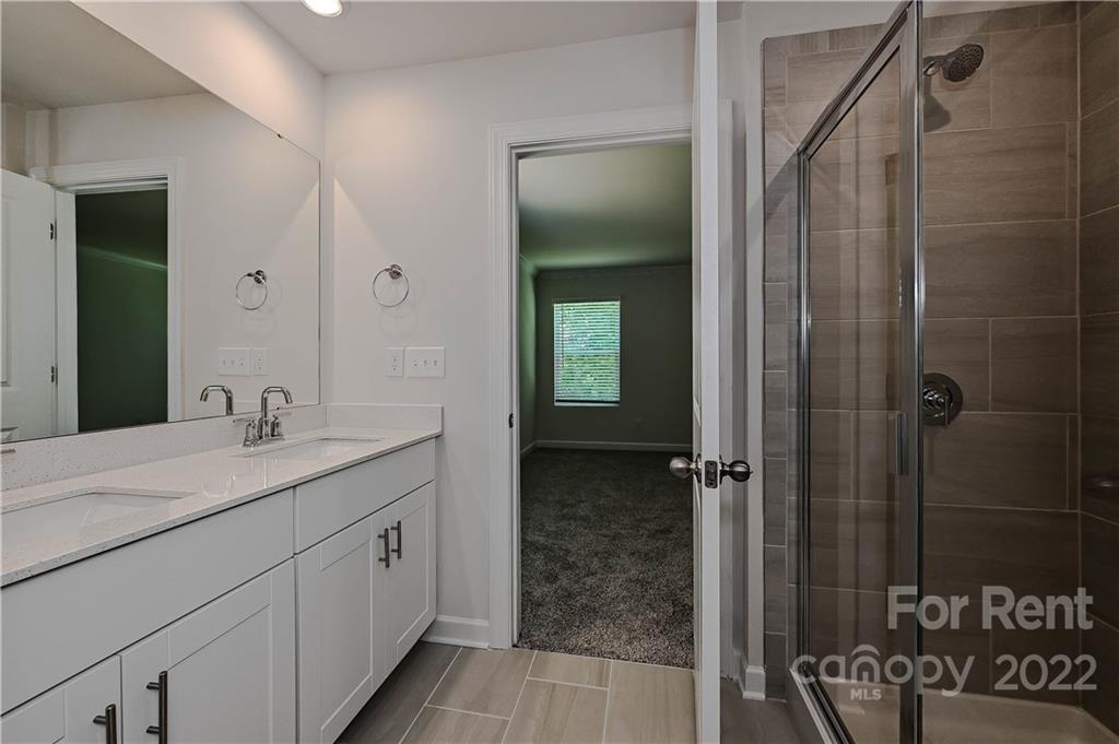 3534 Auburn Curb Road Charlotte, NC 28217 - Photo 9 of 11 a bathroom with a granite countertop sink a mirror and shower