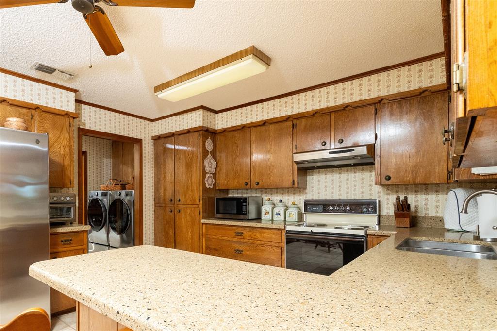 970 Live Oak Road Santo, TX 76472 - Photo 19 of 40 a kitchen with stainless steel appliances a stove a refrigerator and cabinets