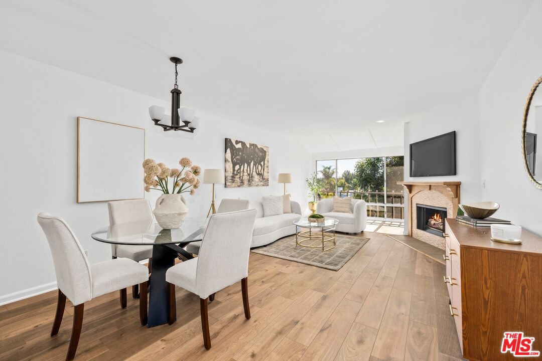 12720 Burbank Boulevard, Unit 318 Valley Village, CA 91607 - Photo 1 of 12 a living room with furniture a fireplace and a flat screen tv