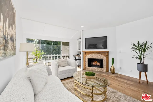 a living room with furniture a fireplace and a floor to ceiling window