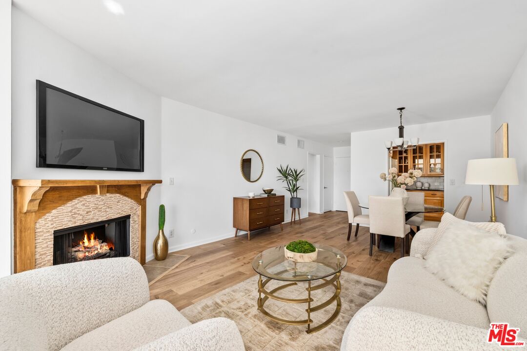 12720 Burbank Boulevard, Unit 318 Valley Village, CA 91607 - Photo 3 of 12 a living room with furniture a flat screen tv and a fireplace