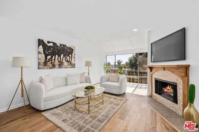 a living room with furniture a flat screen tv and a fireplace