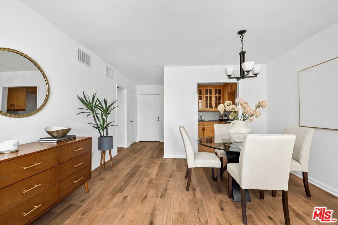 12720 Burbank Boulevard, Unit 318 Valley Village, CA 91607 - Photo 6 of 12 a view of a dining room with furniture and wooden floor