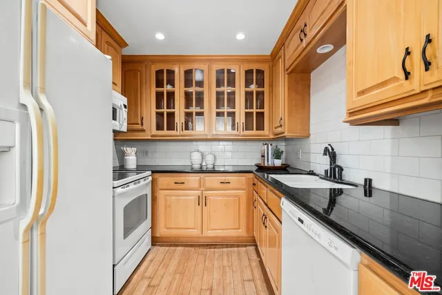 a kitchen with stainless steel appliances granite countertop a sink and dishwasher a stove with wooden floor