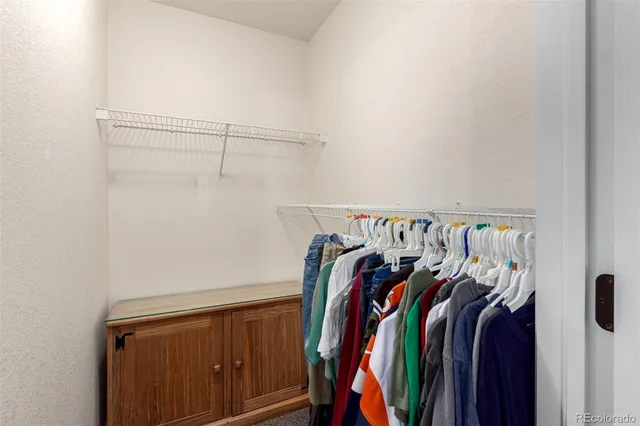 a view of walk in closet with clothes