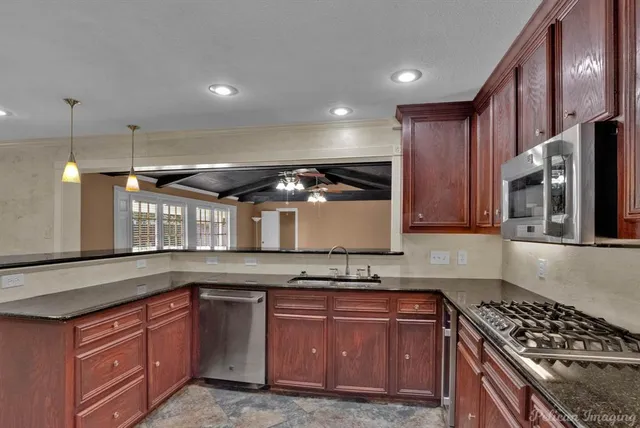 a kitchen with stainless steel appliances granite countertop a stove a sink and a granite counter tops
