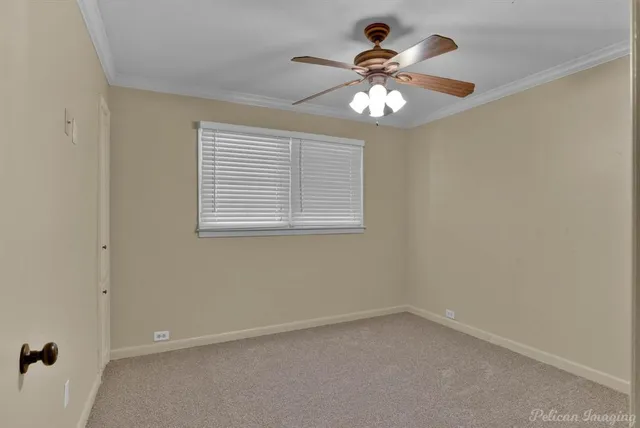 an empty room with chandelier fan and windows