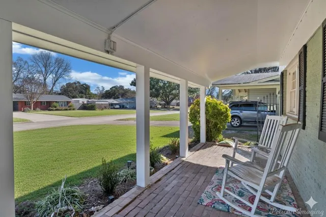 a living room with chairs and a table with garden view
