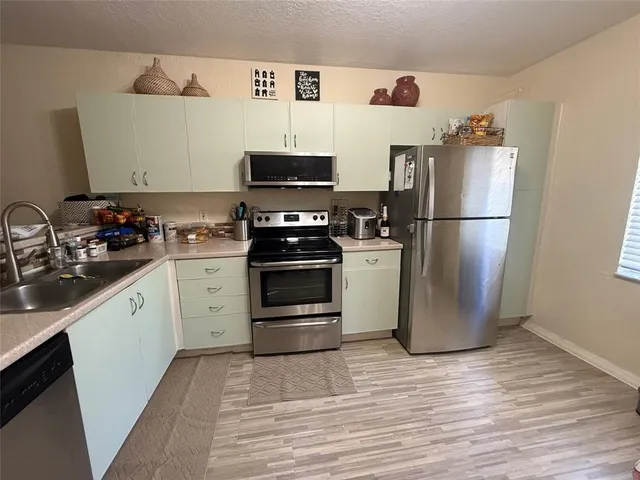 a kitchen with a refrigerator sink and cabinets