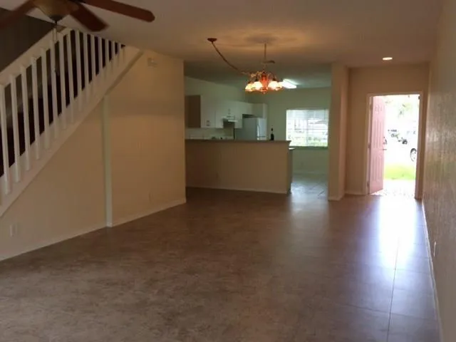 a view of a hallway with wooden floor and a kitchen