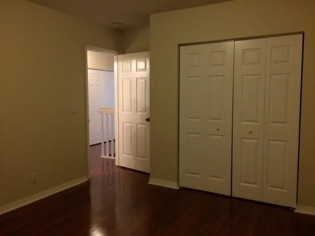 an empty room with wooden floor and closet