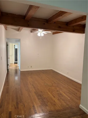 en empty room with wooden floor and windows