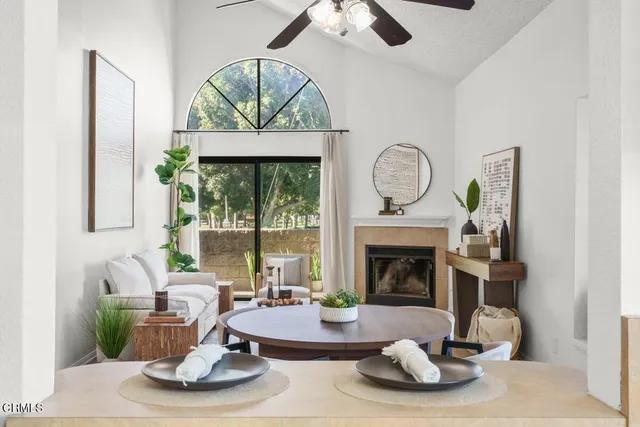 a living room with furniture a fireplace and a floor to ceiling window