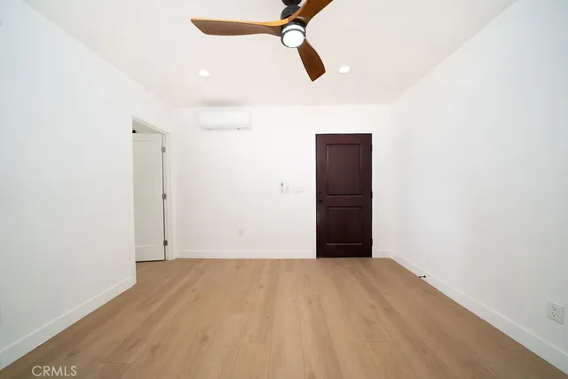 a view of a big room with wooden floor and windows
