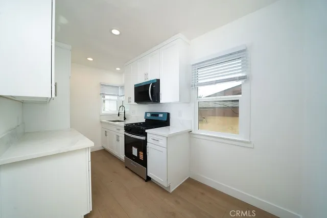a kitchen with a stove a sink and a microwave