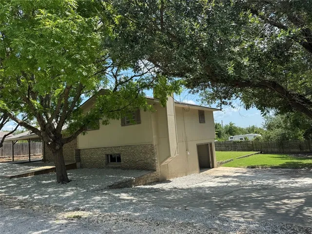 a view of a house with a tree in front of it