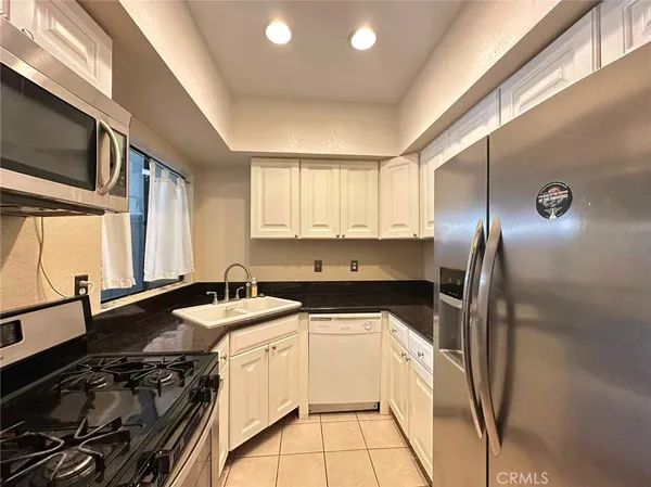a kitchen that has a sink a stove and a refrigerator