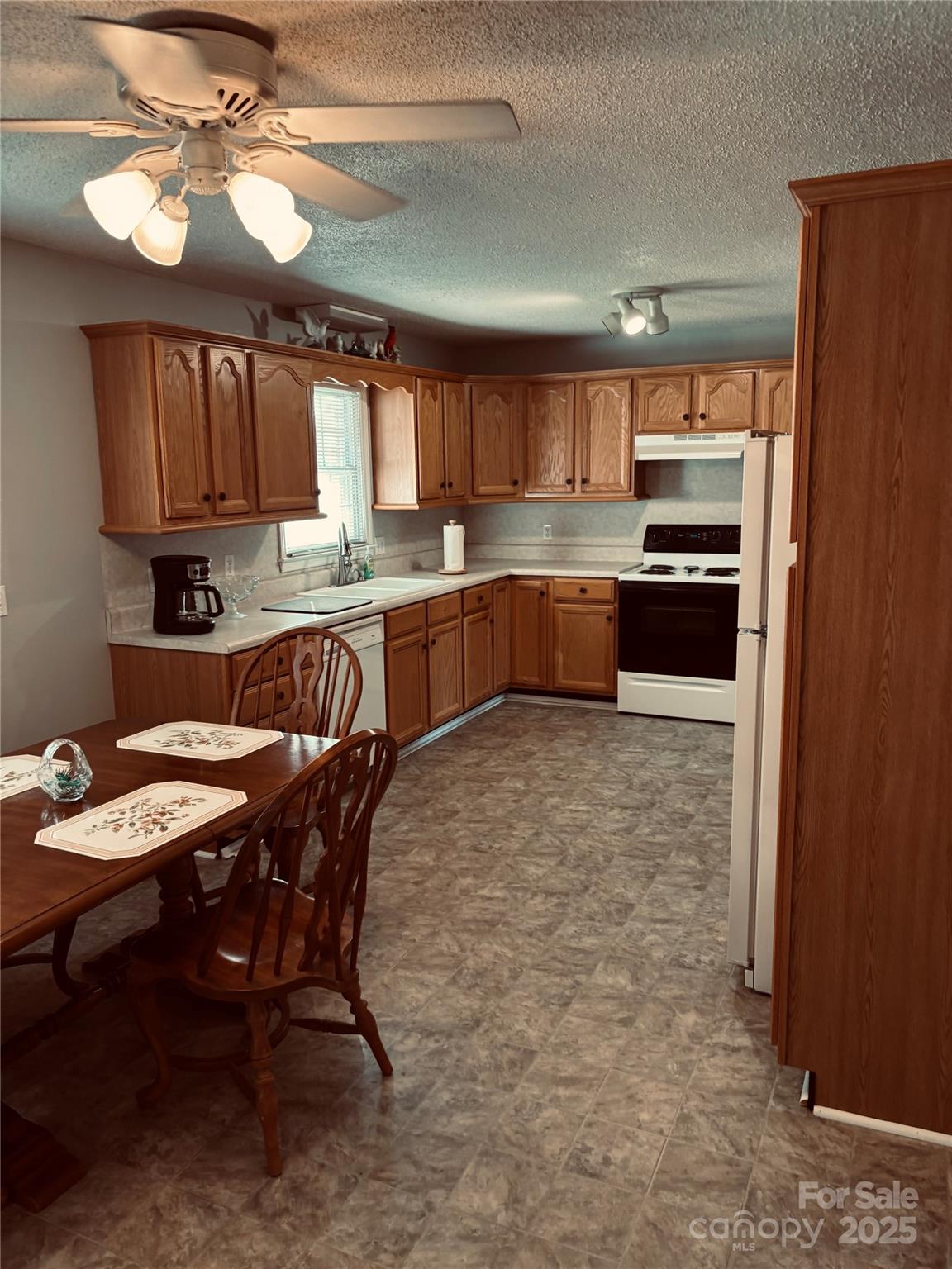 4211 Wolf Pond Road Monroe, NC 28112 - Photo 11 of 36 a kitchen with stainless steel appliances kitchen island granite countertop a table chairs sink and cabinets