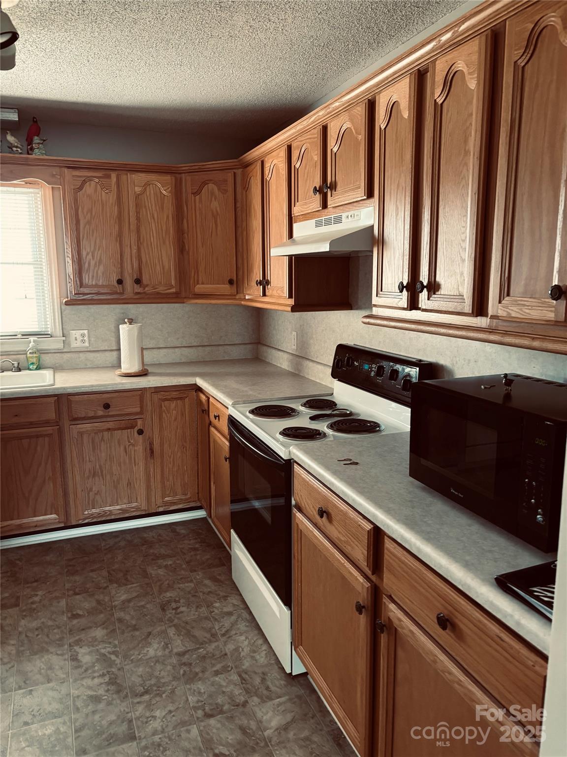 4211 Wolf Pond Road Monroe, NC 28112 - Photo 8 of 36 a kitchen with stainless steel appliances granite countertop a stove a sink and a microwave