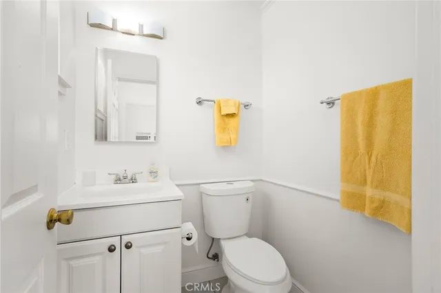 a bathroom with a toilet sink vanity and mirror