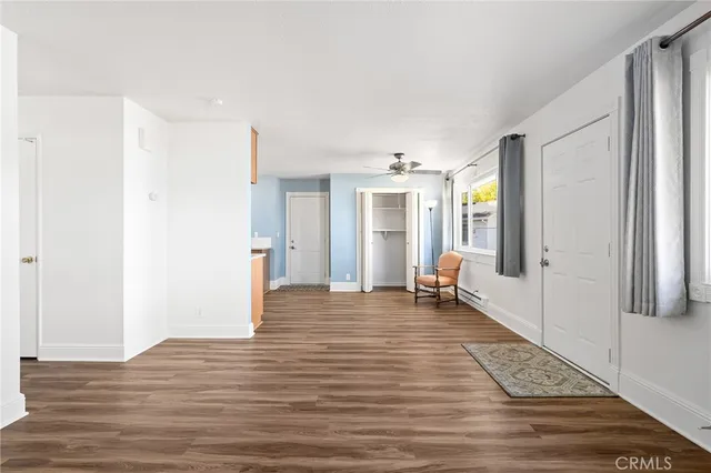 a view of a livingroom with wooden floor and furniture