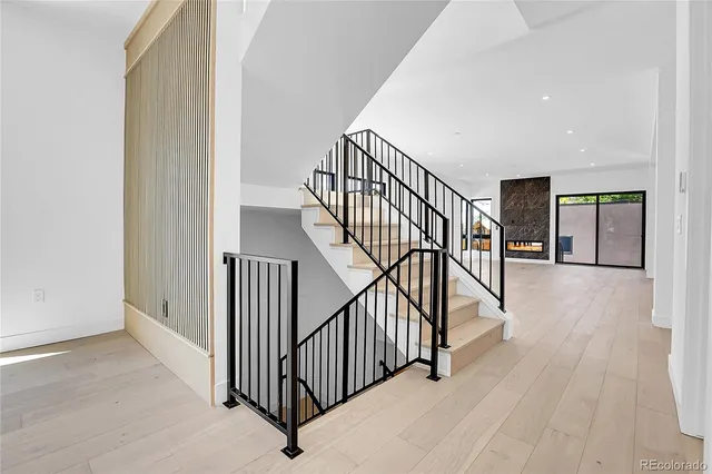 a view of staircase with wooden floor and white walls
