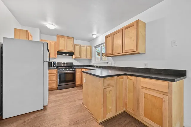 a kitchen with granite countertop white cabinets and white appliances