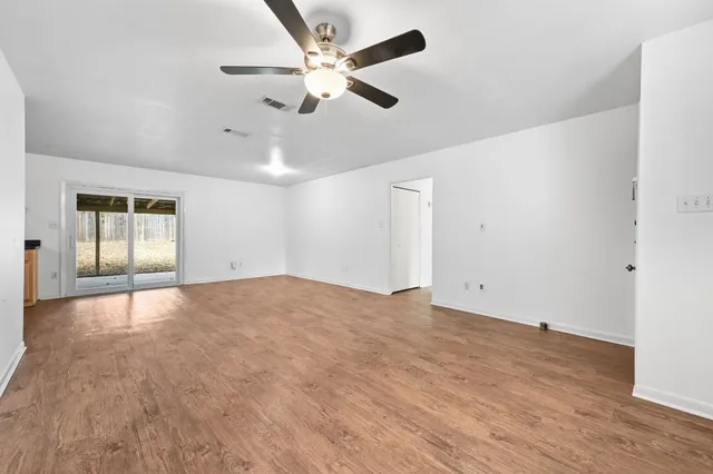 an empty room with fan and windows