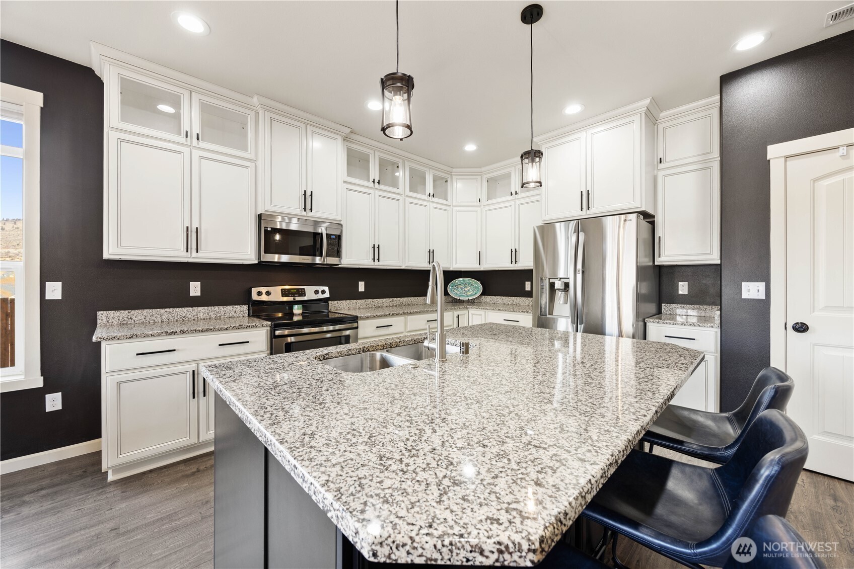 457 Whisper Place Chelan, WA 98816 - Photo 21 of 40 a kitchen with stainless steel appliances granite countertop a sink a stove and a refrigerator