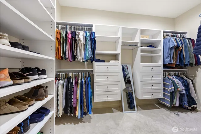 a view of walk in closet with clothes and shoes