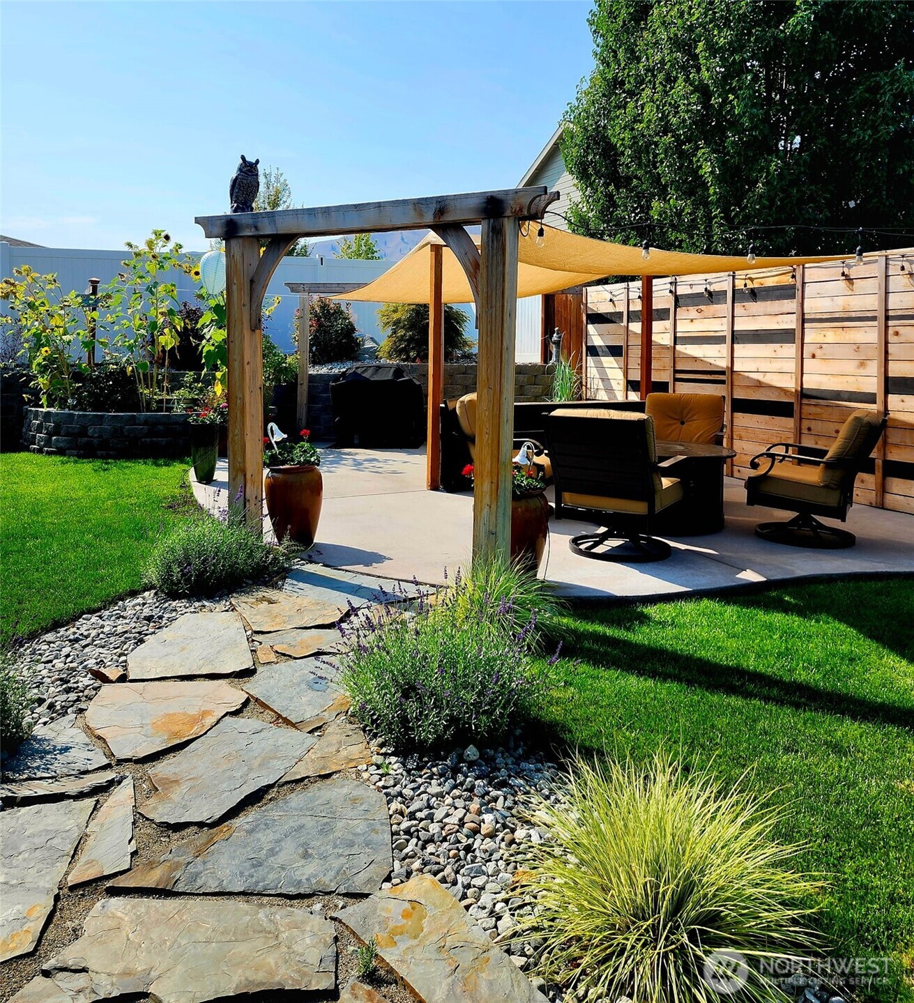 457 Whisper Place Chelan, WA 98816 - Photo 35 of 40 a view of a patio with table and chairs potted plants and palm tree