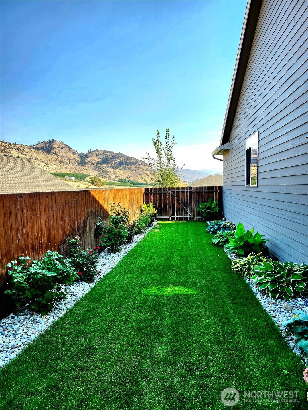 457 Whisper Place Chelan, WA 98816 - Photo 37 of 40 a view of a backyard with potted plants and large tree