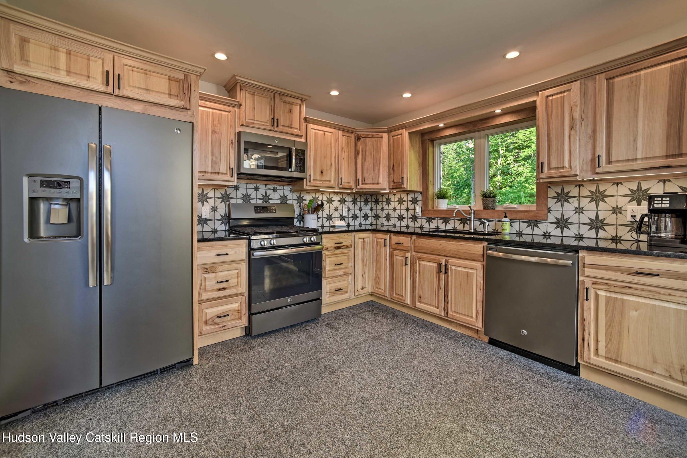 205 Nauvoo Road Windham, NY 12496 - Photo 18 of 31 a kitchen with stainless steel appliances granite countertop a stove a sink dishwasher a refrigerator and cabinets with wooden floor