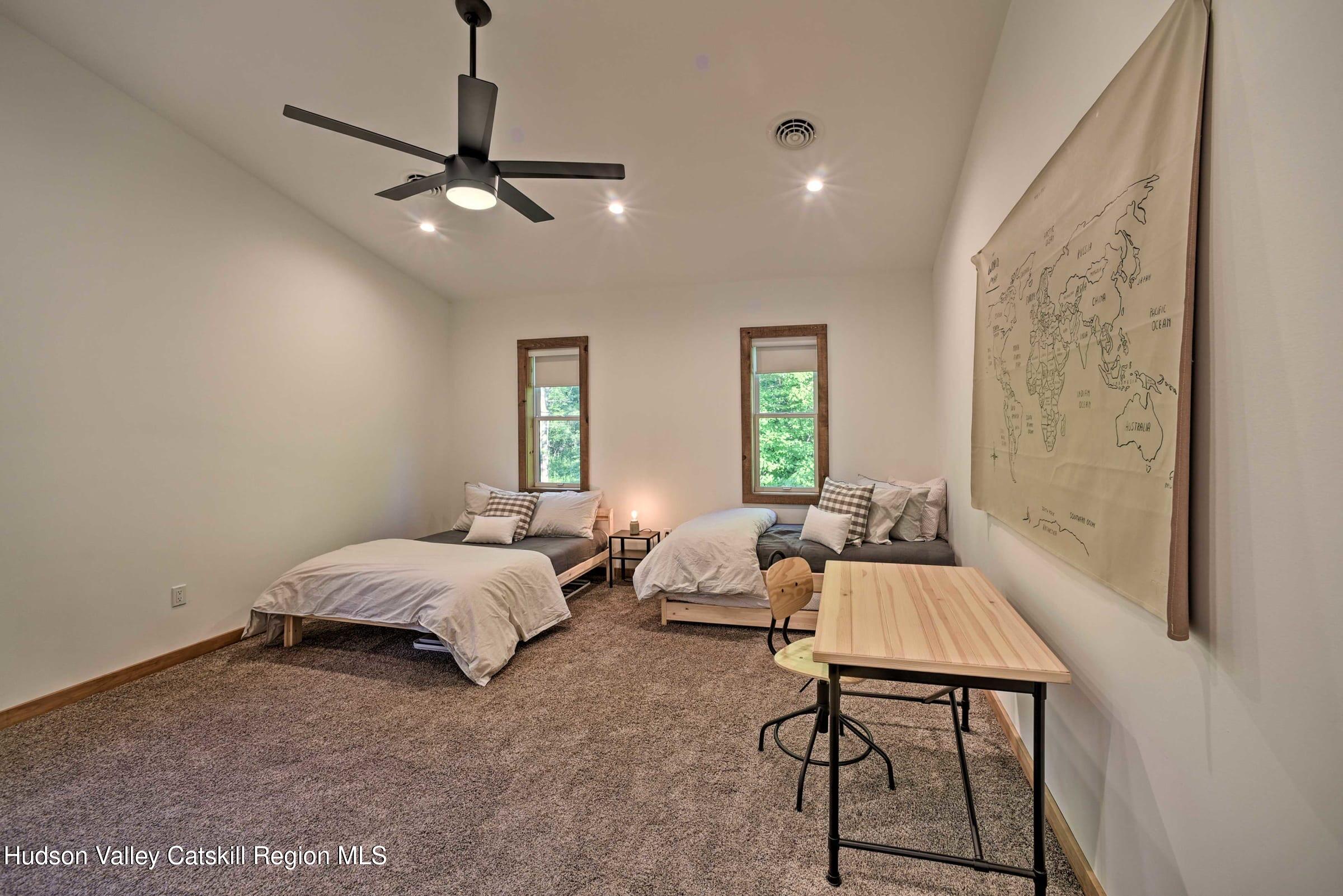 205 Nauvoo Road Windham, NY 12496 - Photo 21 of 31 a spacious bedroom with a bed and a chandelier